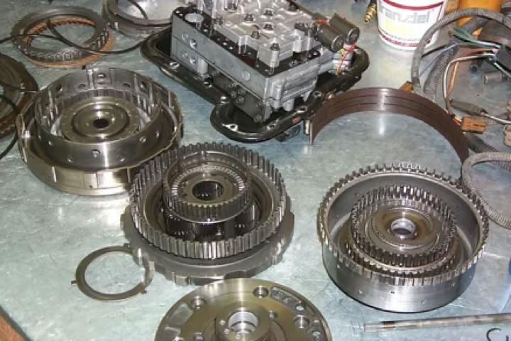 Various mechanical parts and gears arranged on a metal surface.