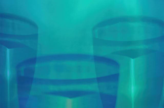 Abstract image with overlapping translucent blue and teal shapes resembling glasses.