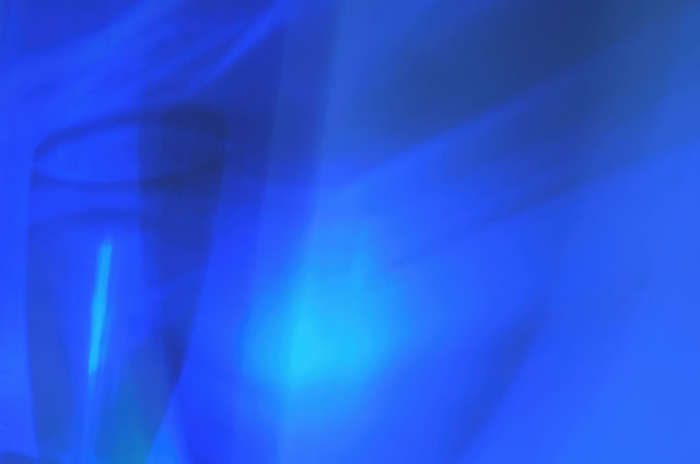 Abstract image with blue tones and a faint outline of a glass.